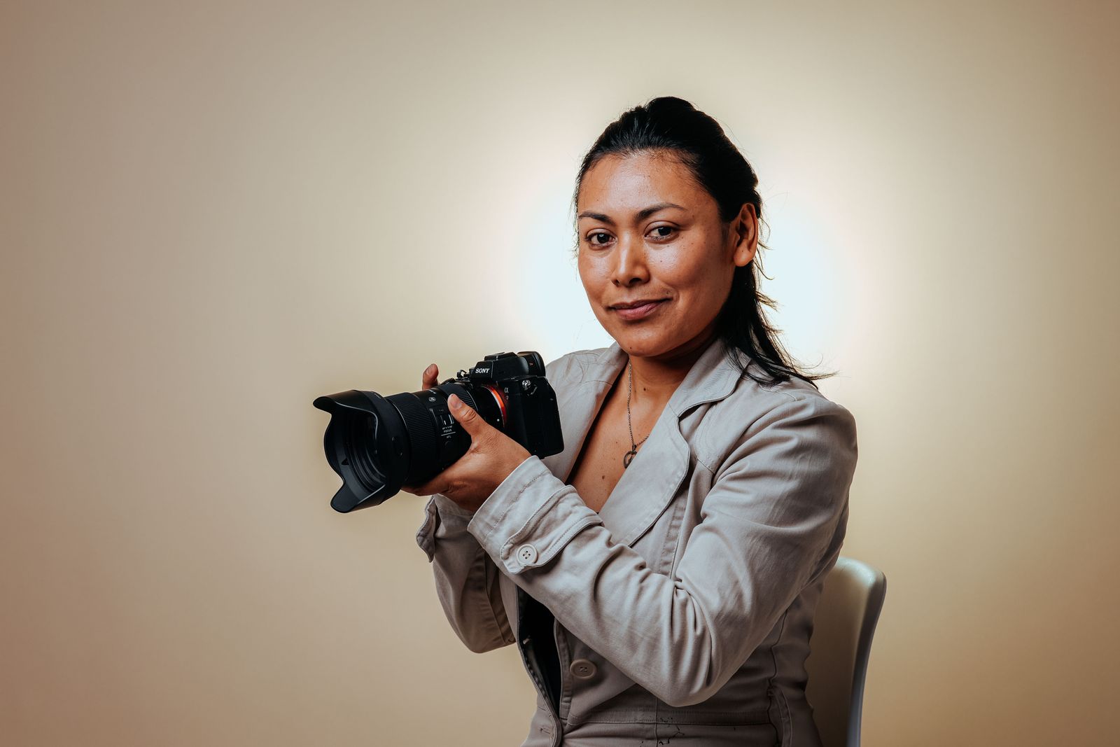 Prowadząca kursu, fotografka portretowa, z aparatem w ręku w swoim studio